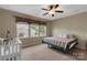 A cozy bedroom with carpet, a crib, a ceiling fan, and natural light from three windows at 417 Brier Knob Dr, Fort Mill, SC 29715
