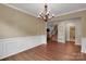 Elegant dining room with classic wainscoting, hardwood floors, chandelier, and seamless view into the living area at 417 Brier Knob Dr, Fort Mill, SC 29715