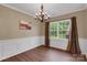 Bright dining area features wainscoting, hardwood floors, chandelier, and window with natural light and view at 417 Brier Knob Dr, Fort Mill, SC 29715