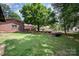 Expansive backyard with mature trees, picnic table, and classic brick exterior of the home at 418 Melody Ln, Shelby, NC 28152