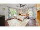 Bright bedroom with large windows, a ceiling fan, floral bedding, and a decorative area rug at 418 Melody Ln, Shelby, NC 28152