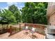 Inviting deck with wooden flooring, chair set, grill, and scenic backyard views at 418 Melody Ln, Shelby, NC 28152