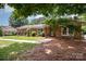 Traditional brick home featuring a well-manicured lawn, walkway, and verdant landscaping at 418 Melody Ln, Shelby, NC 28152