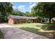 Brick home with mature landscaping and a concrete driveway, surrounded by lush greenery at 418 Melody Ln, Shelby, NC 28152