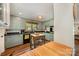 Cozy kitchen featuring green cabinets, dark countertops, an island and hardwood flooring at 418 Melody Ln, Shelby, NC 28152