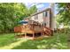 Beautifully landscaped backyard with an elevated deck, steps and mature shade trees at 4333 Poplar Grove Dr, Charlotte, NC 28269