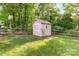 Charming storage shed with a wooden fence surrounded by a lush green yard at 4333 Poplar Grove Dr, Charlotte, NC 28269