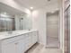 Bright bathroom featuring double vanity with white cabinets, neutral tile flooring, and an open doorway to a walk-in closet at 4404 Dusty Orchard Rd, Kannapolis, NC 28081