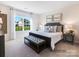A cozy bedroom with a large window, neutral tones, a tufted bench and a beautiful view at 4415 Dusty Orchard Rd, Kannapolis, NC 28081