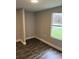 Small bedroom with neutral paint, wood look floors, and large window at 4417 Grier St, Gastonia, NC 28056