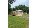 Exterior view of a mobile home with a new deck and a small storage shed at 4417 Grier St, Gastonia, NC 28056