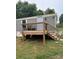 Exterior of home with new wooden deck and railings, side entry door, and gray siding at 4417 Grier St, Gastonia, NC 28056