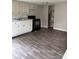 A cozy kitchen features white cabinets, laminate counter tops, and wood grain vinyl floors at 4417 Grier St, Gastonia, NC 28056