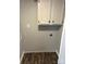 A small laundry room with laminate floors and upper cabinets at 4417 Grier St, Gastonia, NC 28056