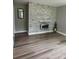 Living room featuring a decorative stone wall, fireplace, and sleek floors at 4524 Cinderella Rd, Charlotte, NC 28213