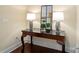 Close-up of an elegant console table showcasing decor lamps and a mirror in a neutrally painted room at 4620 Piedmont Row Dr # 308, Charlotte, NC 28210