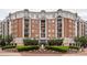 Elegant brick building with beautiful landscaping, including a fountain and manicured shrubs in a formal design at 4620 Piedmont Row Dr # 308, Charlotte, NC 28210