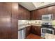 Well-equipped kitchen featuring stainless steel appliances and dark wood cabinets at 4620 Piedmont Row Dr # 308, Charlotte, NC 28210