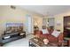 Comfortable living room featuring a balcony, orange sofa, TV, and easy access to a dining area at 4620 Piedmont Row Dr # 308, Charlotte, NC 28210