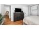 Comfortable bedroom with hardwood floors, a dresser with a TV, and ample natural light at 4924 Farm Pond Ln, Charlotte, NC 28212