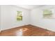Bright bedroom featuring hardwood floors and natural light from two windows at 4924 Farm Pond Ln, Charlotte, NC 28212