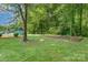 Exterior shot of playground with swings and grass, pool beyond fence at 4924 Farm Pond Ln, Charlotte, NC 28212