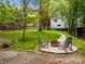Scenic backyard featuring a firepit and seating area, surrounded by lush greenery and trees at 5016 Celeste Ct, Charlotte, NC 28270