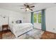 Bright bedroom features a cozy queen-sized bed, a ceiling fan, and a window with lovely blue curtains at 5016 Celeste Ct, Charlotte, NC 28270