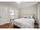 Cozy bedroom featuring a bed with white comforter, pillows and hardwood floors with neutral colored walls at 5016 Celeste Ct, Charlotte, NC 28270
