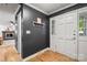 Welcoming entryway with a black accent wall, white trim, and hardwood floors leading to a cozy living space at 5016 Celeste Ct, Charlotte, NC 28270