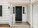 Inviting entryway with a dark green front door, white trim, sidelights, and a covered porch area at 5016 Celeste Ct, Charlotte, NC 28270