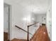 Bright hallway featuring wood floors, white walls, and a stylish chandelier with a staircase to the left at 5016 Celeste Ct, Charlotte, NC 28270