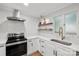 Bright kitchen boasts stainless steel appliances, white cabinets, herringbone tile backsplash, and modern countertops at 5016 Celeste Ct, Charlotte, NC 28270