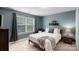 Bedroom with a plush rug, bed with decorative pillows, and a large window overlooking the yard at 5044 Dockside Ct, Matthews, NC 28104