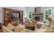 Cozy living room featuring a stone fireplace, hardwood floors, a large entertainment center, and plush seating at 5044 Dockside Ct, Matthews, NC 28104