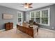 Comfortable home office featuring a large desk, fan, and ample natural light at 5044 Dockside Ct, Matthews, NC 28104