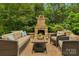 Outdoor patio featuring a stone fireplace, comfortable seating, and a charming outdoor living space at 5044 Dockside Ct, Matthews, NC 28104