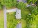 Aerial view showcases the house, driveway, and fenced backyard with mature trees at 605 Cobb St, Lowell, NC 28098