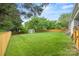 Spacious fenced backyard with lush green grass and mature trees, great for outdoor activities at 605 Cobb St, Lowell, NC 28098