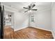 Comfortable bedroom with hardwood floors, a ceiling fan, and access to other rooms at 605 Cobb St, Lowell, NC 28098