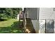 Back exterior of the home with wooden stairs leading to deck and walk out basement at 608 E E St, Newton, NC 28658