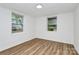Bright bedroom with wood-look flooring and two windows providing natural light at 613 N Rhyne St, Gastonia, NC 28054