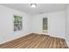 This bright bedroom features wood-look flooring, large windows, and a door to the deck at 613 N Rhyne St, Gastonia, NC 28054