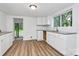 Well-lit kitchen featuring white cabinets, modern countertops, and vinyl flooring at 613 N Rhyne St, Gastonia, NC 28054