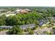 High-angle view of townhouses nestled among green trees near commercial area, highlighting urban convenience at 6518 Point Comfort Ln, Charlotte, NC 28226