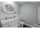 Elegant half-bathroom featuring a marble vanity, decorative mirror, and modern fixtures with wainscoting at 6518 Point Comfort Ln, Charlotte, NC 28226