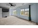 Spacious bedroom with two large windows, a ceiling fan, and neutral carpeting at 6518 Point Comfort Ln, Charlotte, NC 28226