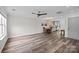 Bright living area with hardwood floors, ceiling fan, and open layout to the kitchen with lots of natural light at 6518 Point Comfort Ln, Charlotte, NC 28226