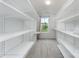 Spacious walk-in closet with custom shelving and a window providing natural light, perfect for organization at 6726 Carradale Way, Charlotte, NC 28278