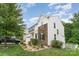 A two-story home featuring a white exterior with stone accents, a well-maintained lawn, and blue skies at 6726 Carradale Way, Charlotte, NC 28278